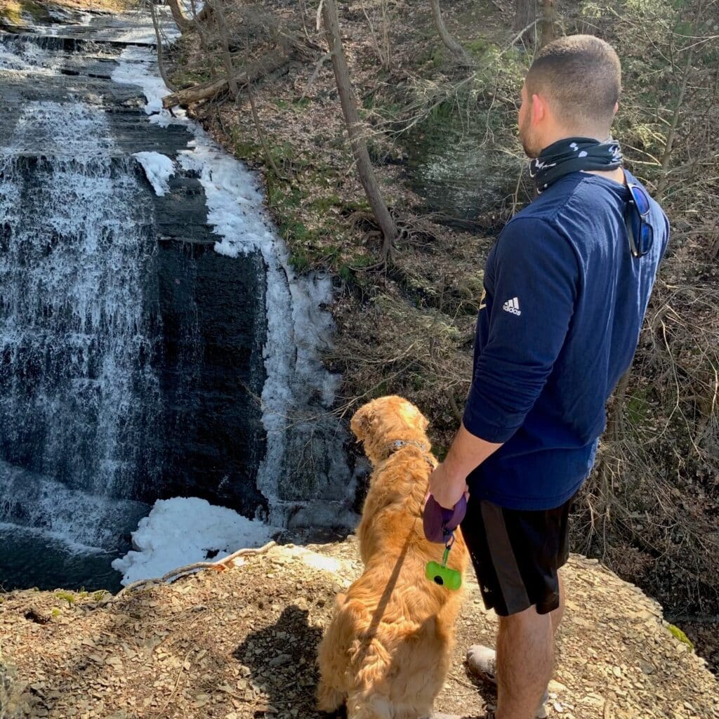 Stratton Drivanos with dog near waterfall