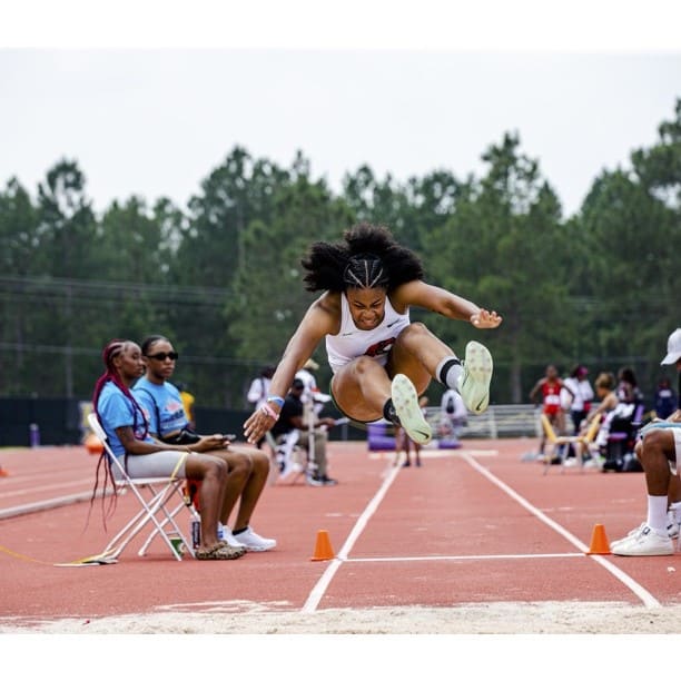 Janai Lyons doing hurdles on the track