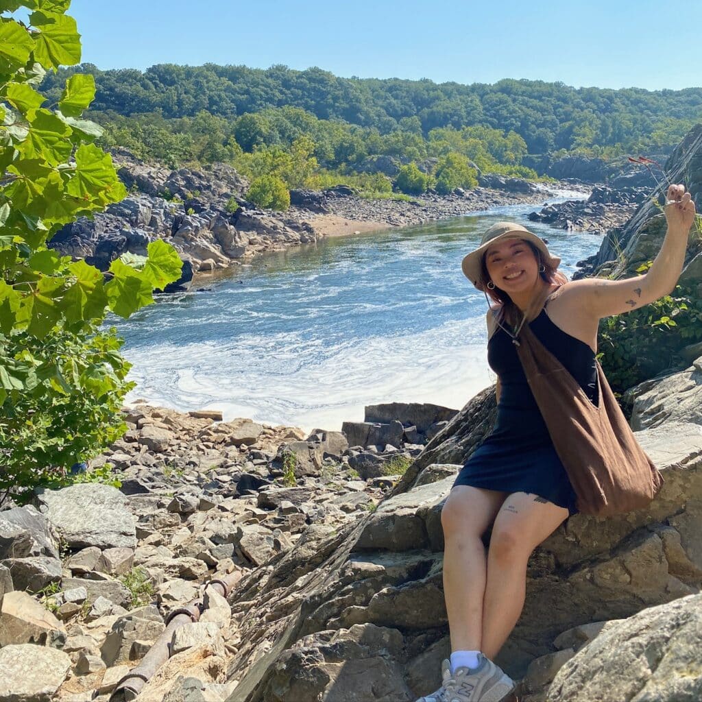 Joanne Chen sitting on a rock in a valley