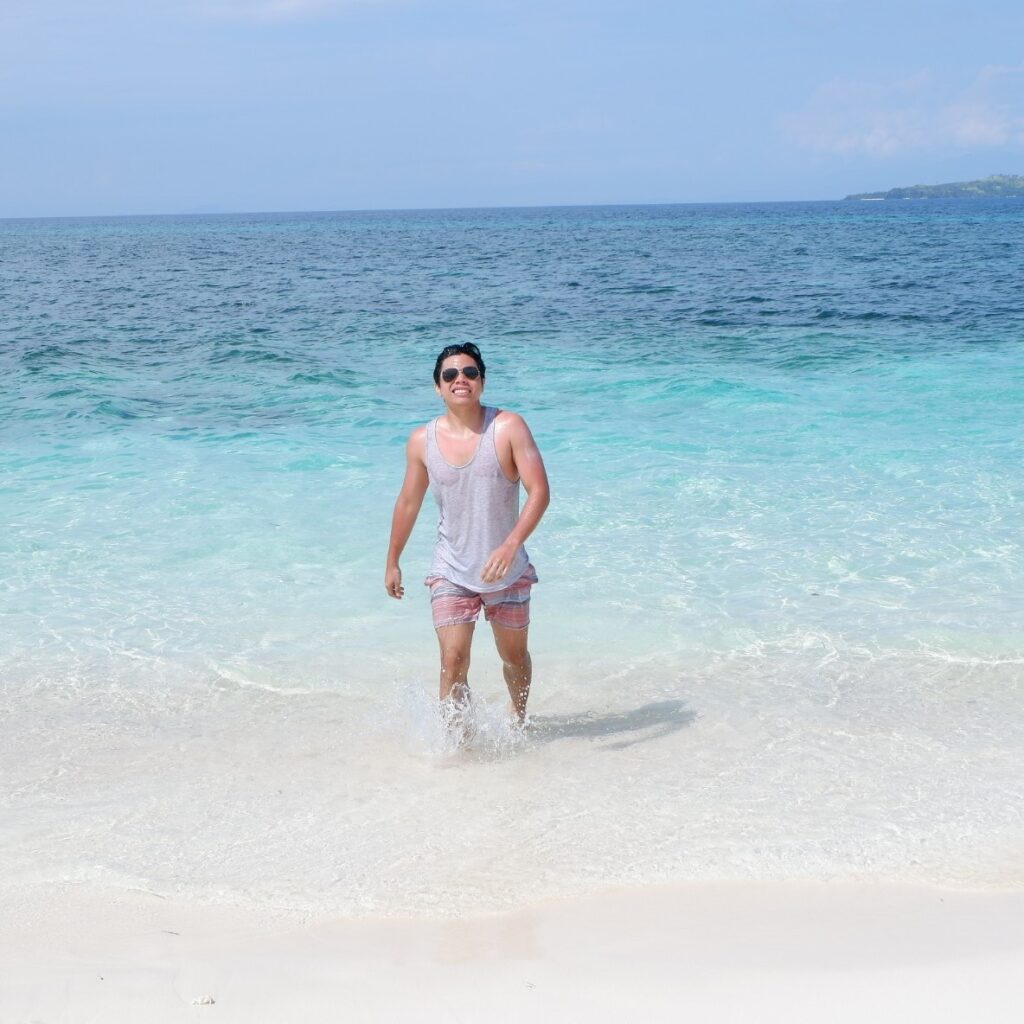 Mark Miclat walking out of the ocean