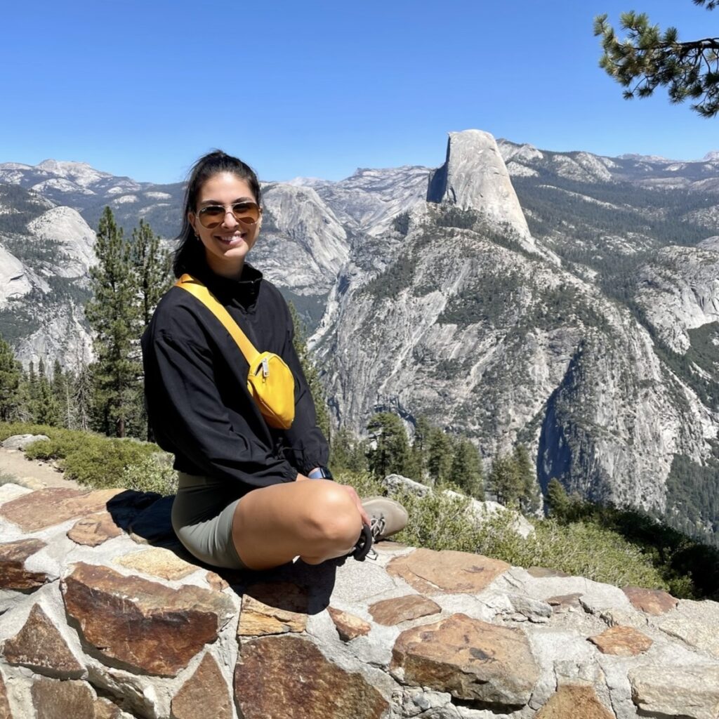 Alexandra D'Annibale sitting ona rock in front of a mountain