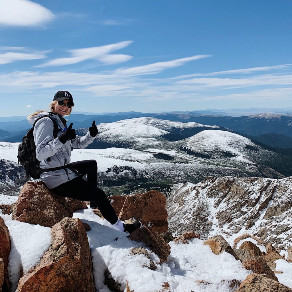 Rachel Johnson sitting on a snow covered mountain