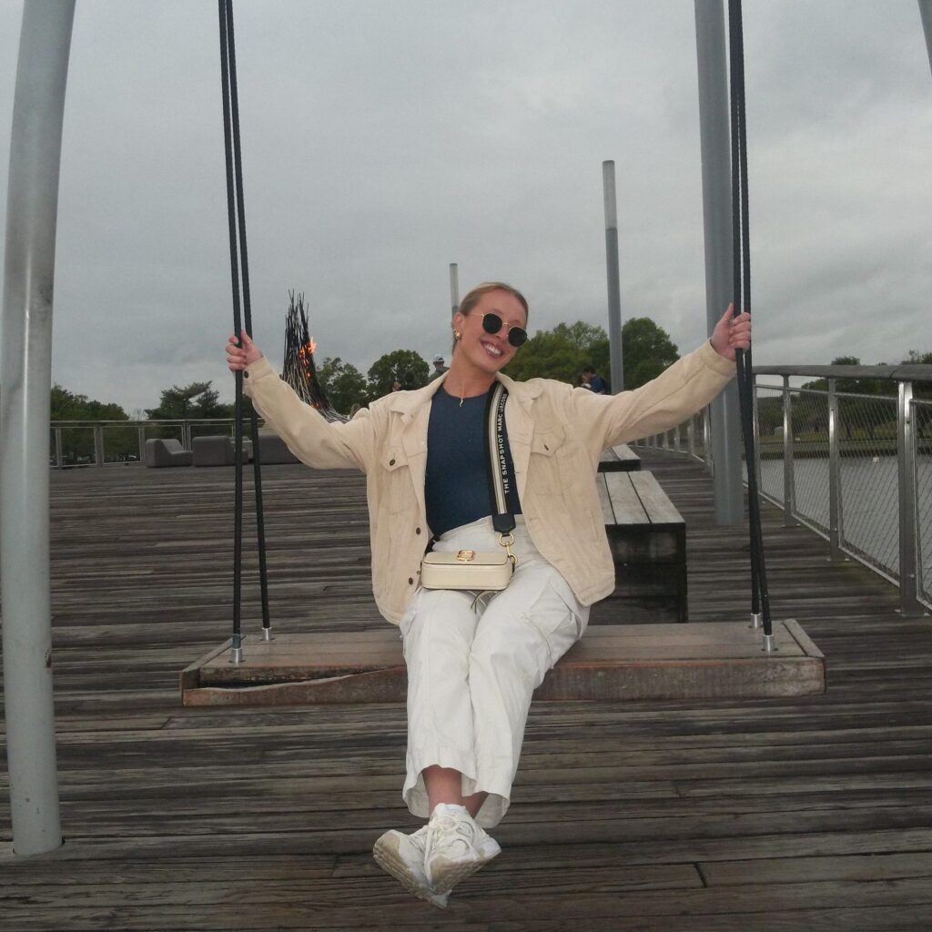 Danielle Freund on an outdoor swing on a dock