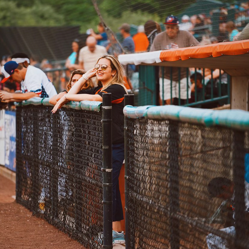 Jess von kessel in a softball dugout watching the game