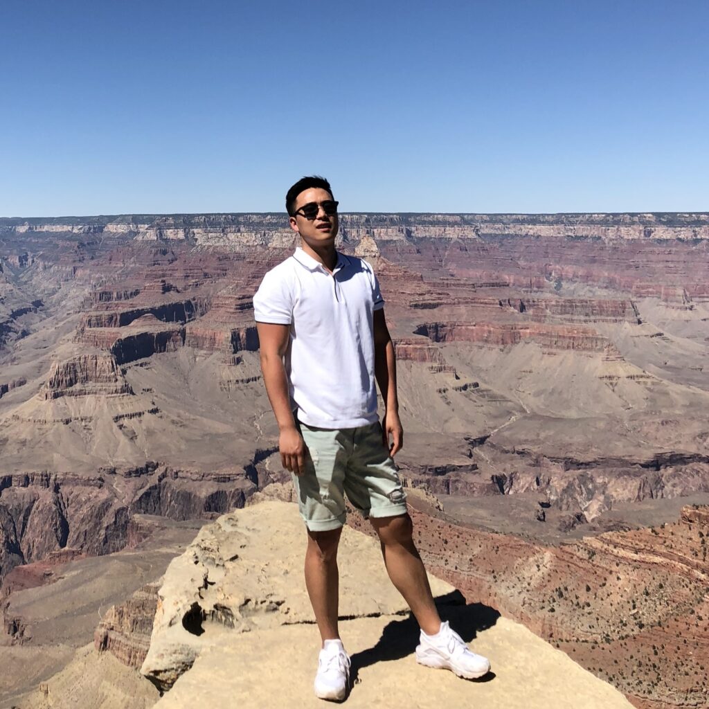 Kyle kwon standing on a mountain rock