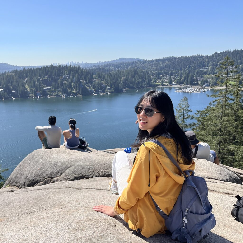 Lucy Zeng sitting on a rock