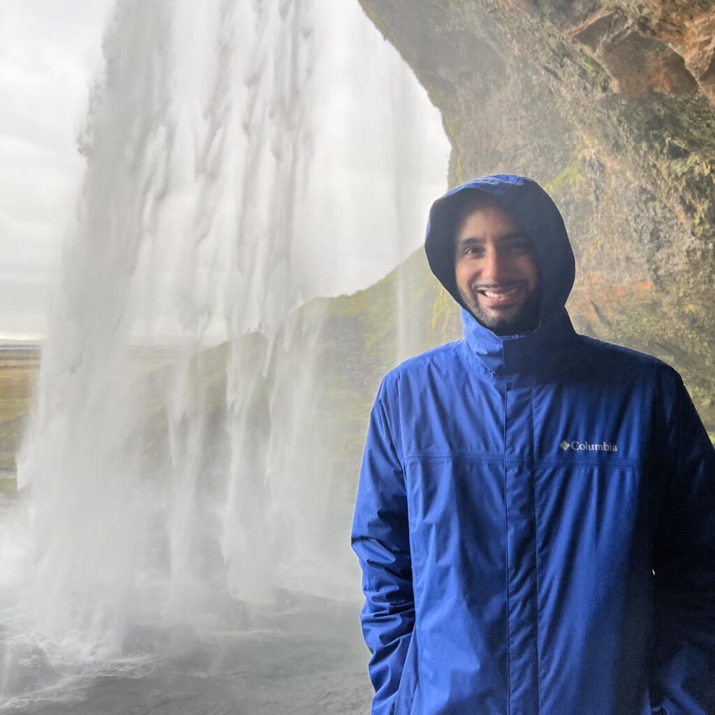 Philippe Corbanese standing behind a waterfall