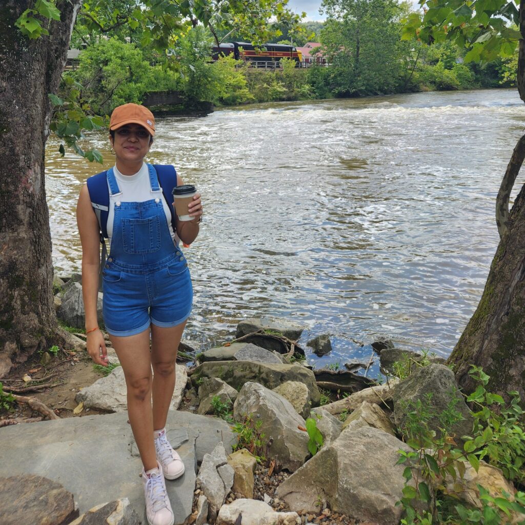 hiral patel drinking coffee in a forrest