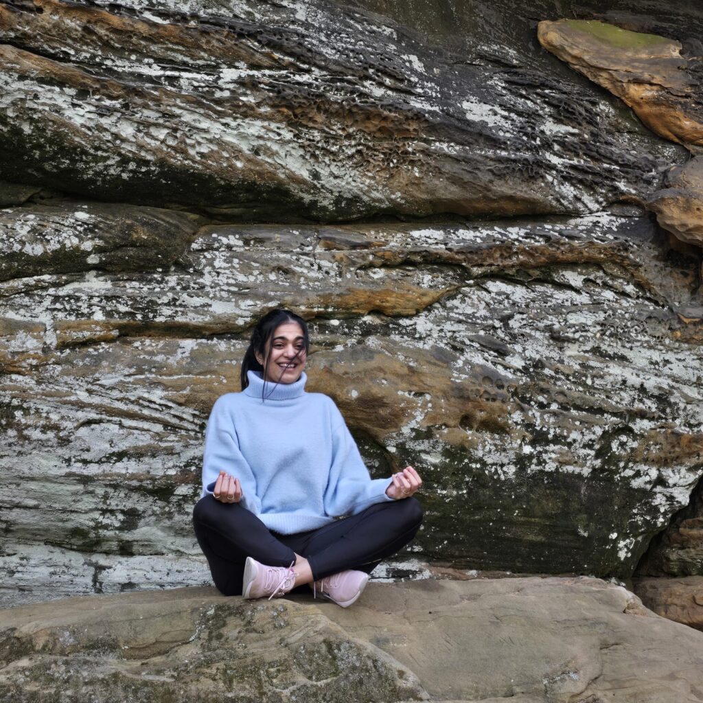 hiral patel meditating on a rock