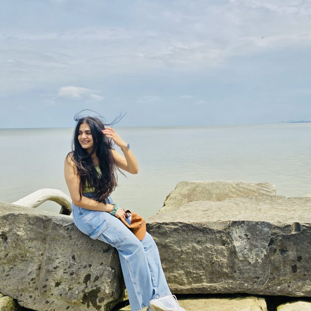 hiral patel on a rock at the beach